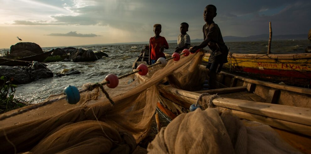 a group of people standing on top of a boat near the ocean